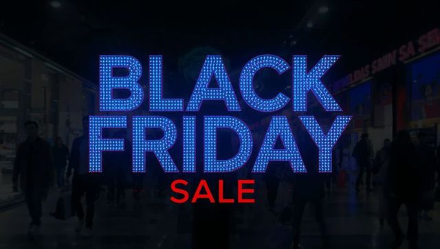Black friday led sale sign lighting busy mall corridor with shoppers silhouettes