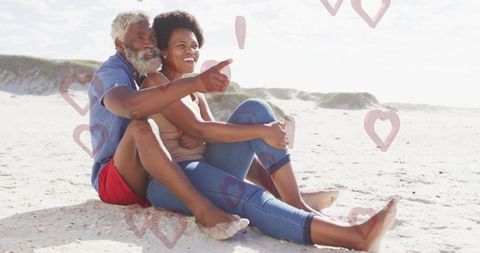 Romantic Couple Embracing at Beach with Floating Hearts