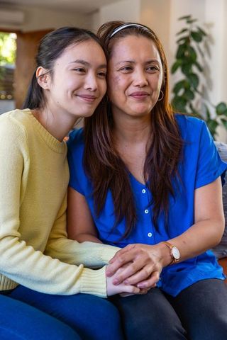 Mother and daughter bonding at home in warm lighted room