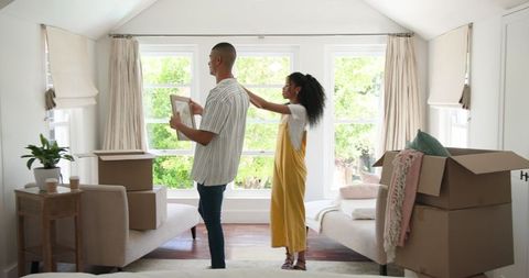 Couple unpacking and decorating new home living room together