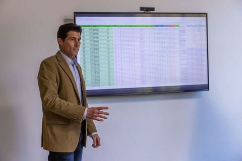 Businessman presenting spreadsheet analysis in modern office
