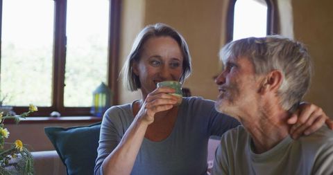 Happy Senior Couple Enjoying Coffee and Conversation at Home
