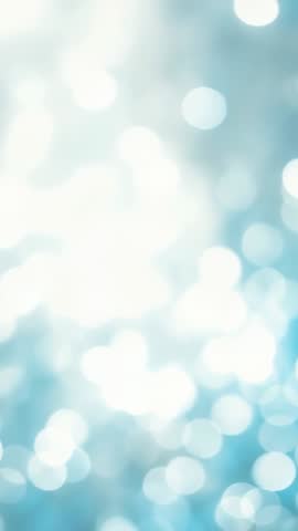 Vertical bokeh glow background for mobile video showing soft blue-white abstract light haze