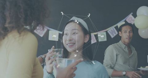 Smiling asian woman enjoying conversation at birthday gathering with festive decor