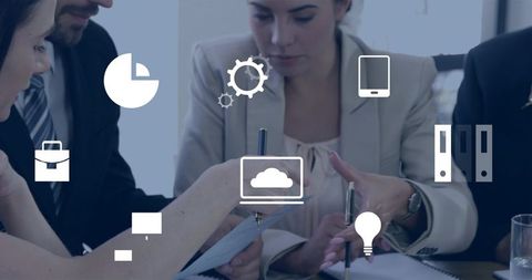 Business team collaborating on documents with cloud computing icons overlaid for planning