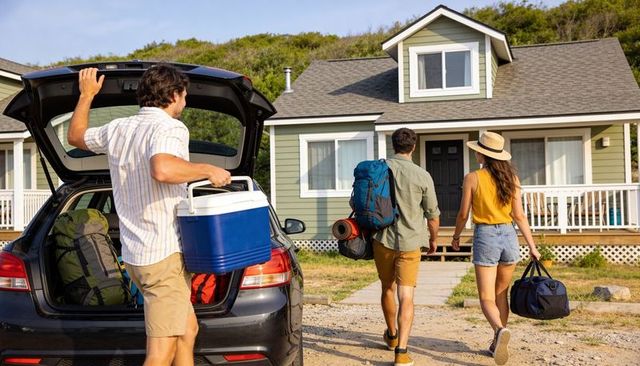 Friends unloading car for coastal cottage weekend getaway