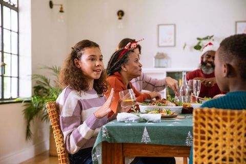 Family Enjoying Holiday Dinner Around Wooden Table