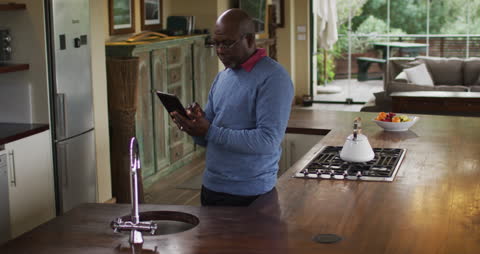 Senior Man Using Digital Tablet in Modern Kitchen