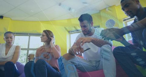 Colleagues engaging in office discussion with modern technology overlay