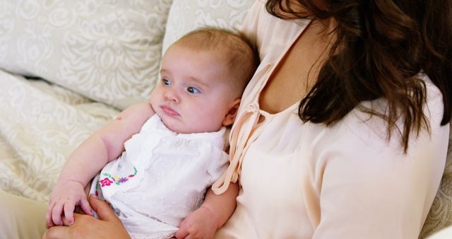 Mother Holding Baby on Sofa in Cozy Home Environment - Download Free Stock Images Pikwizard.com