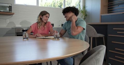 Smiling couple collaborating at kitchen table for creative planning