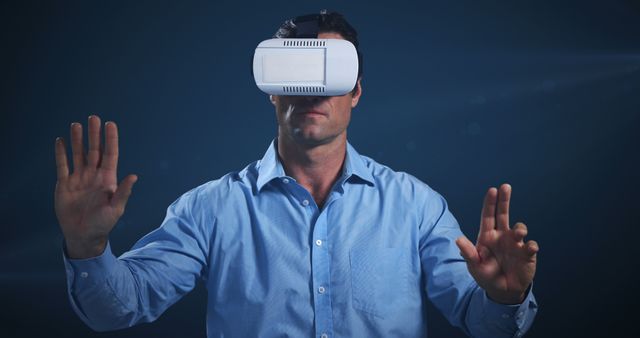 Caucasian businessman in blue shirt wearing vr headset on blue background. Virtual reality, communication, connections and technology.