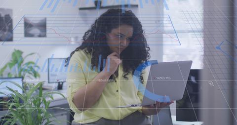Businesswoman Analyzing Digital Data on Laptop in Modern Office