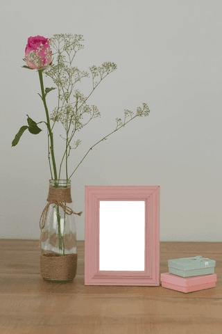 transparent rose vase and empty pink photo frame on wooden table - Download Free Stock Videos Pikwizard.com
