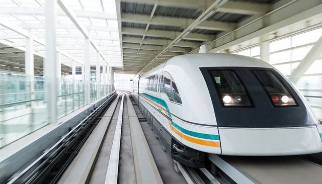 High-Speed Train Accelerating on Elevated Guideway Through Modern Glass-and-Steel Station