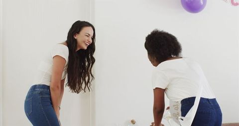 Two Friends Celebrating Indoor Party with Balloons and Laughter