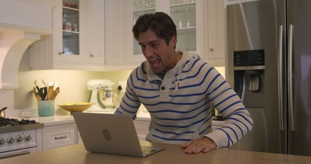 Excited Man Cheering While Using Laptop at Home in Kitchen - Download Free Stock Images Pikwizard.com