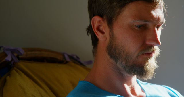 Focused caucasian man with beard sitting in sunny room, copy space - Download Free Stock Photos Pikwizard.com