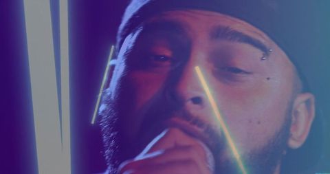 Bearded Man Singing under Neon Lights in Concert