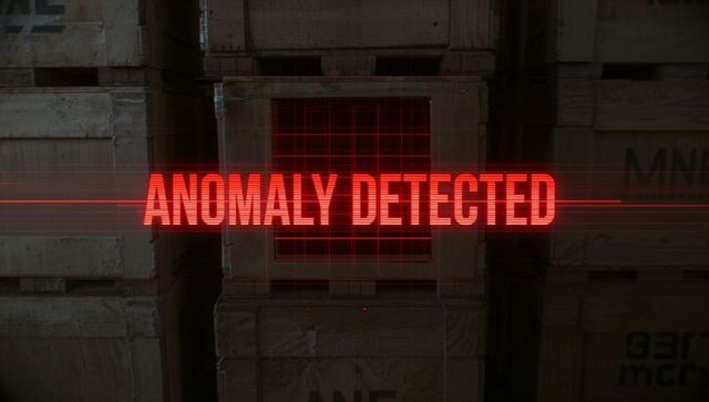 Red Holographic ANOMALY DETECTED Alert Projecting Over Stacked Crates Scanning Warehouse