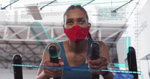 Woman wearing red mask pushing cardio machine handles with futuristic hud overlay
