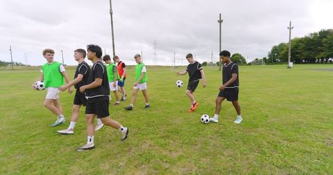 Diverse Team of Teenage Boys Practicing Soccer Outdoors