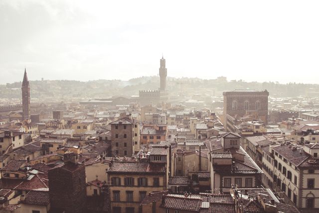 Overlooking historic European city with mist covering rooftops and medieval architecture. Ideal for travel brochures, architecture magazines, and blogs highlighting European destinations or discussing urban photography. Suitable for showcasing travel quotes or digital backgrounds in presentations.