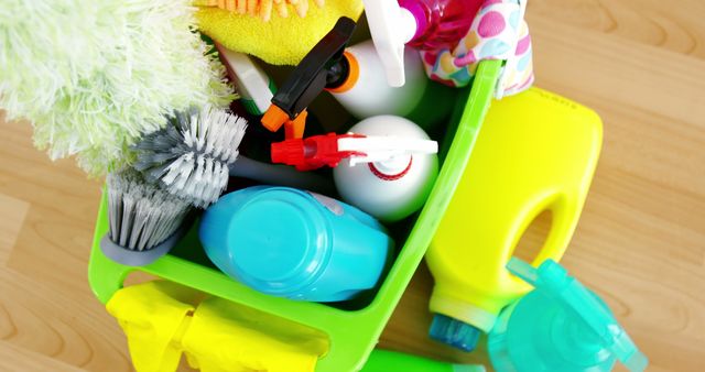 A variety of cleaning supplies and tools are neatly organized in a green caddy, with copy space. Essential for maintaining cleanliness and hygiene, these items are commonly used in households and commercial spaces.