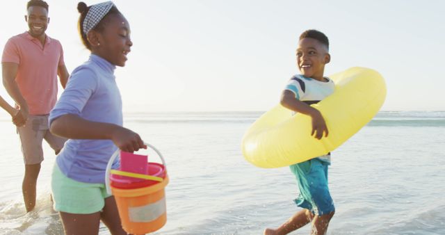 Happy African American family enjoying beach day with kids playing in the surf - Download Free Stock Images Pikwizard.com