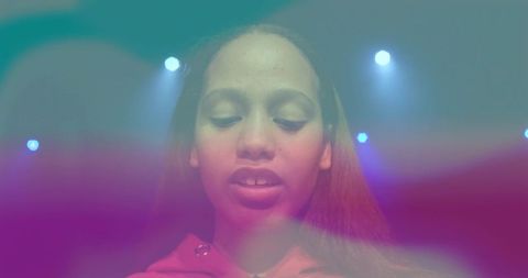 Teen girl center stage under colorful spotlights and haze