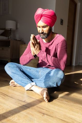 Indian Man Meditating Peacefully at Home in Sunlit Room