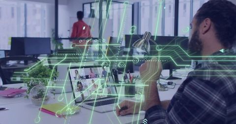 Bearded developer holding lamp reviewing virtual meeting with holographic UI in open office