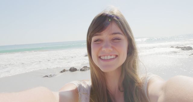 Portrait of happy caucasian woman with long brown hair at sunny beach. Vacation, summer and lifestyle, unaltered.