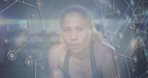 Focused female athlete breathing heavily after workout with futuristic network overlay