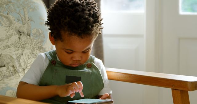 Young Child Engrossed in Mobile Game After School - Download Free Stock Images Pikwizard.com