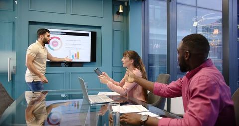 Diverse team analyzing reports during dynamic business presentation