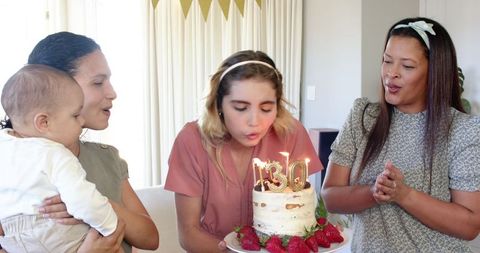 Friends Celebrating Birthday with Cake and Candles in Cozy Living Room