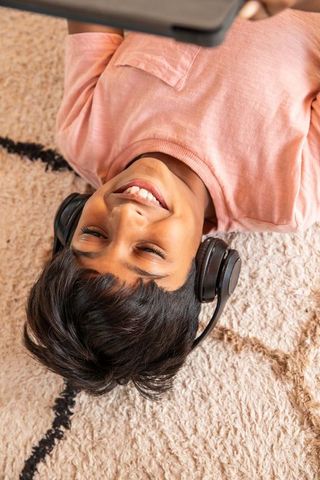 Teenage boy relaxing with laptop and headphones at home