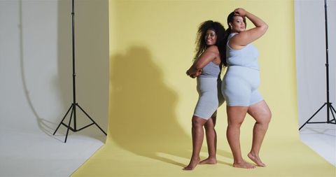 Confident Diverse Women Posing in Fashion Studio with Yellow Background