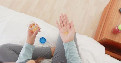Woman Taking Vitamin Capsules in Relaxed Home Setting