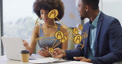 Professionals collaborating over digital network map on laptop for team strategy planning