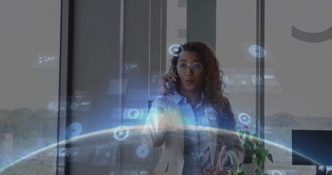 Woman executive using augmented reality interface while making phone call in modern office