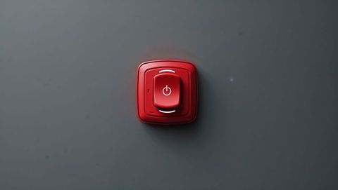Red power button with glowing icon on dark background, red alert button concept
