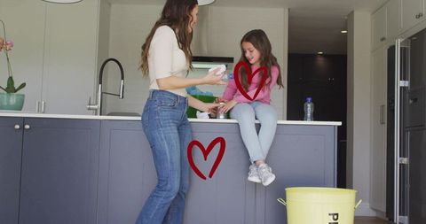 Mother sharing cleaning moment with daughter on kitchen island in minimalist modern home