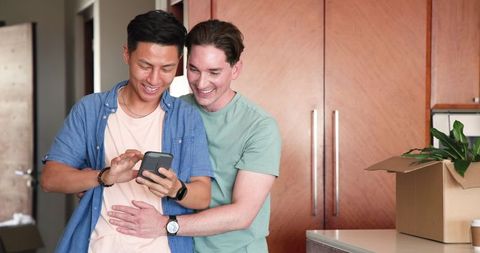 Happy Diverse Male Couple Enjoying Smartphone Together