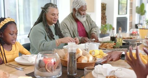 Multigenerational Family Sharing Cozy Holiday Meal Around Sunlit Dining Table