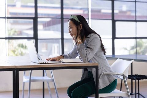 Focused Asian Women Working on Laptop in Modern Office