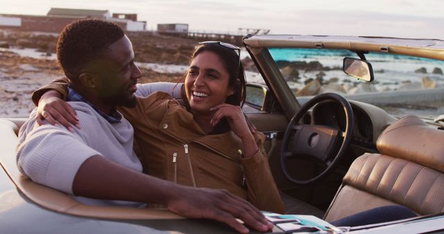 African american couple embracing each other while sitting in the convertible car on the road. road trip travel and adventure concept