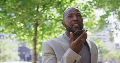 Confident Businessman Recording Voice Note in Urban Setting