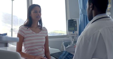 Patient and doctor consulting in hospital room setting
